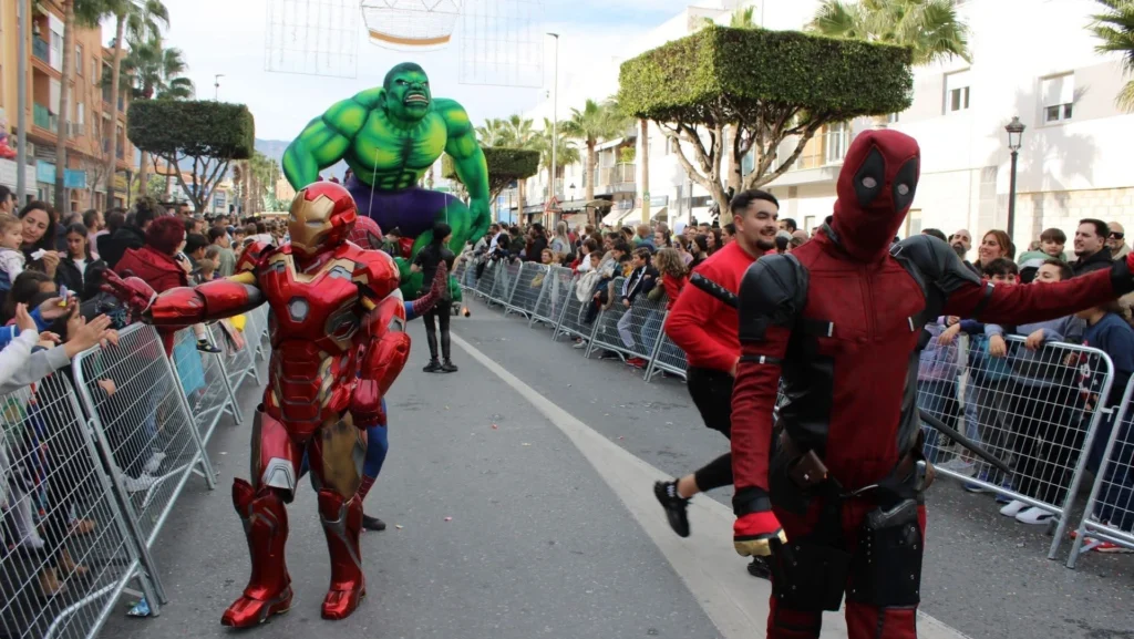 Pasacalles de superhéroes recorriendo calle principal en fiestas populares de Málaga