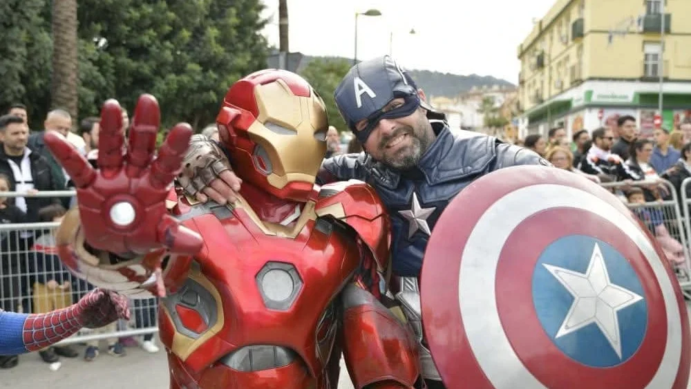 Niños interactuando con superhéroes en pasacalles de evento municipal de Málaga